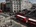 a group of people walking on a street with buses and people