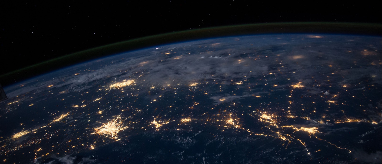 The earth from low level orbit at night featuring many illuminated cities