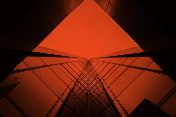 looking up a tall building with a red sky