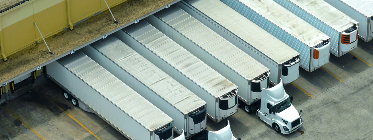 a group of semi trucks parked in a warehouse