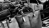 a group of black leather handbags